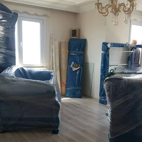 Salonda koruma örtüsüne sarılmış koltuk takımı